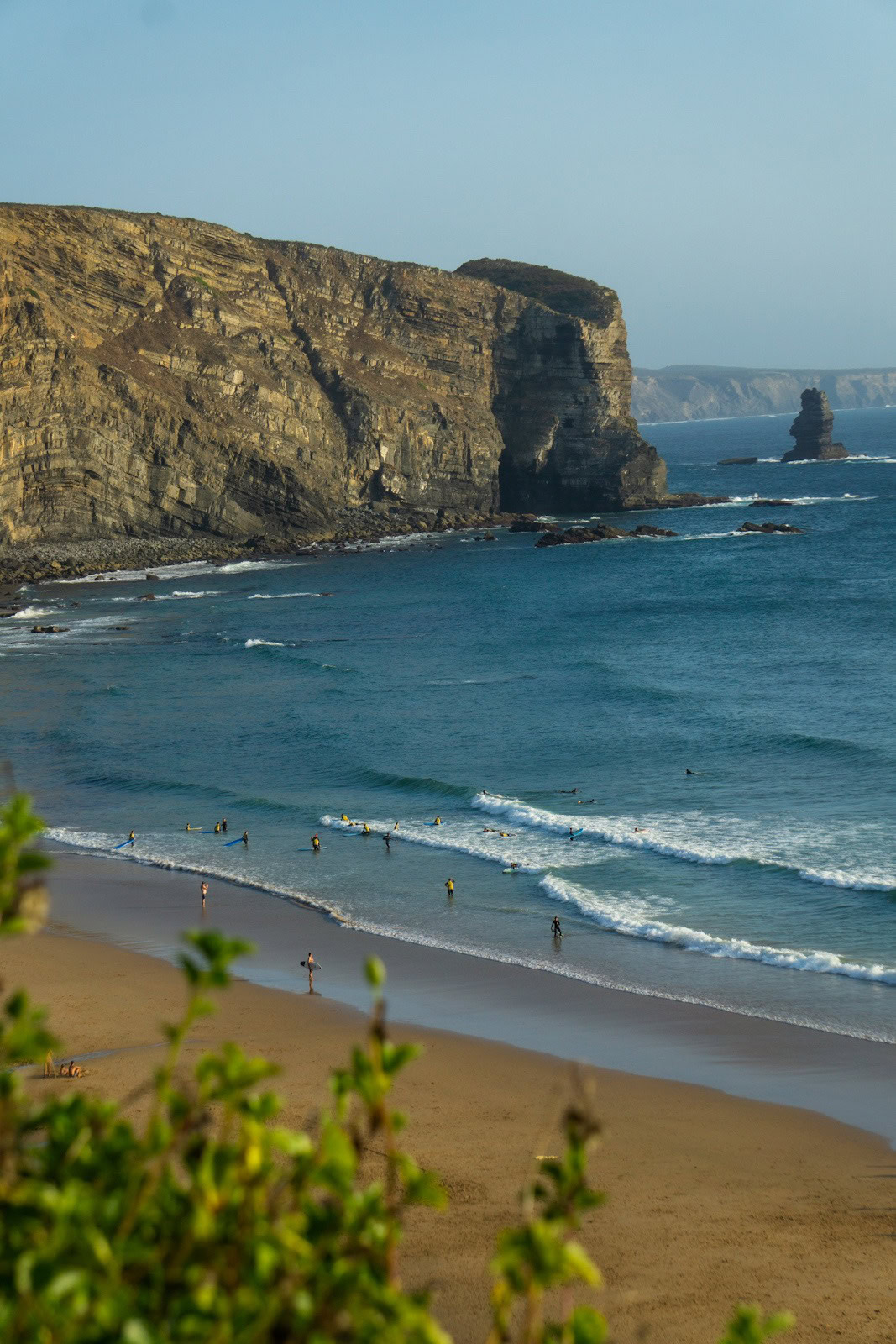 Arrifana beach with surfers and dramatic Algarve cliffs