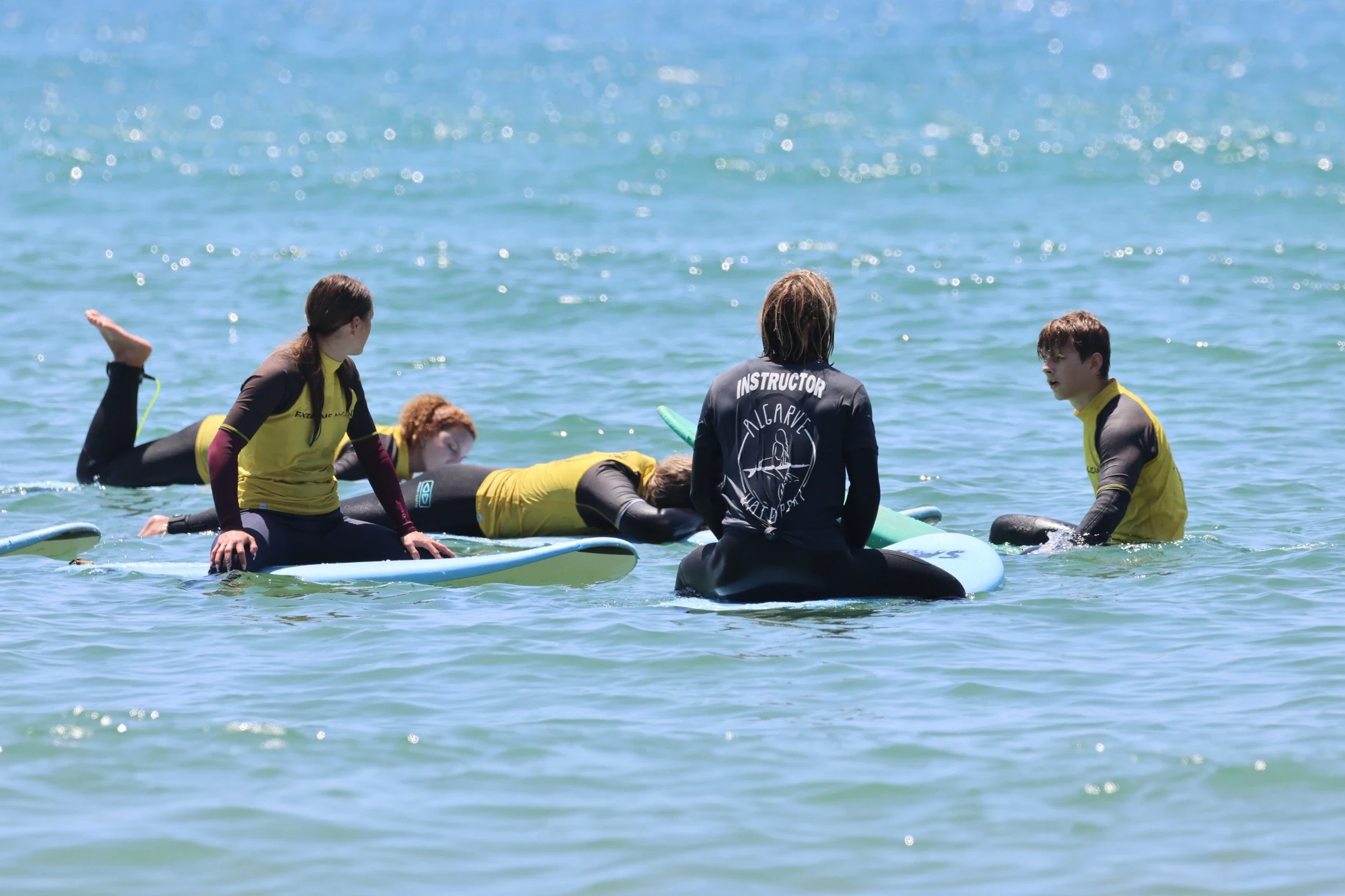 Surf instructor with students sitting on boards in the water — Algarve Watersport Lagos
