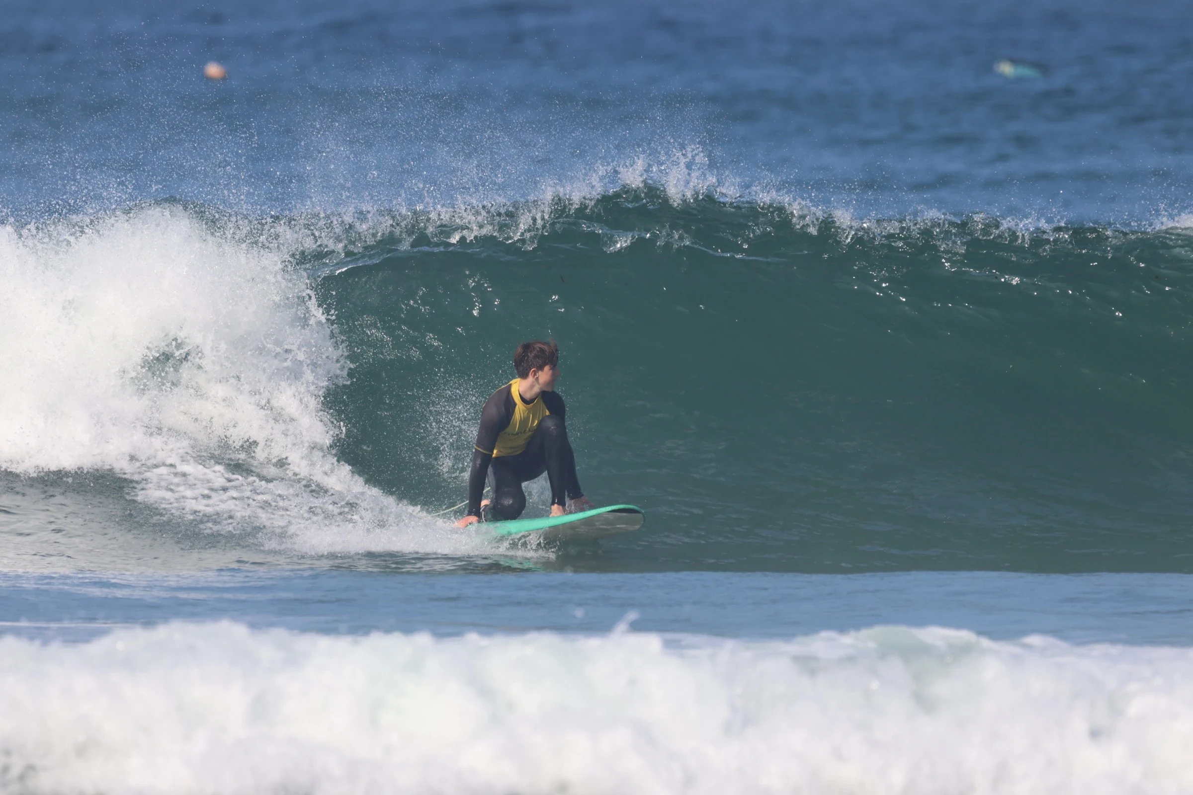 Surf student doing a bottom turn on a big green wave in the Algarve