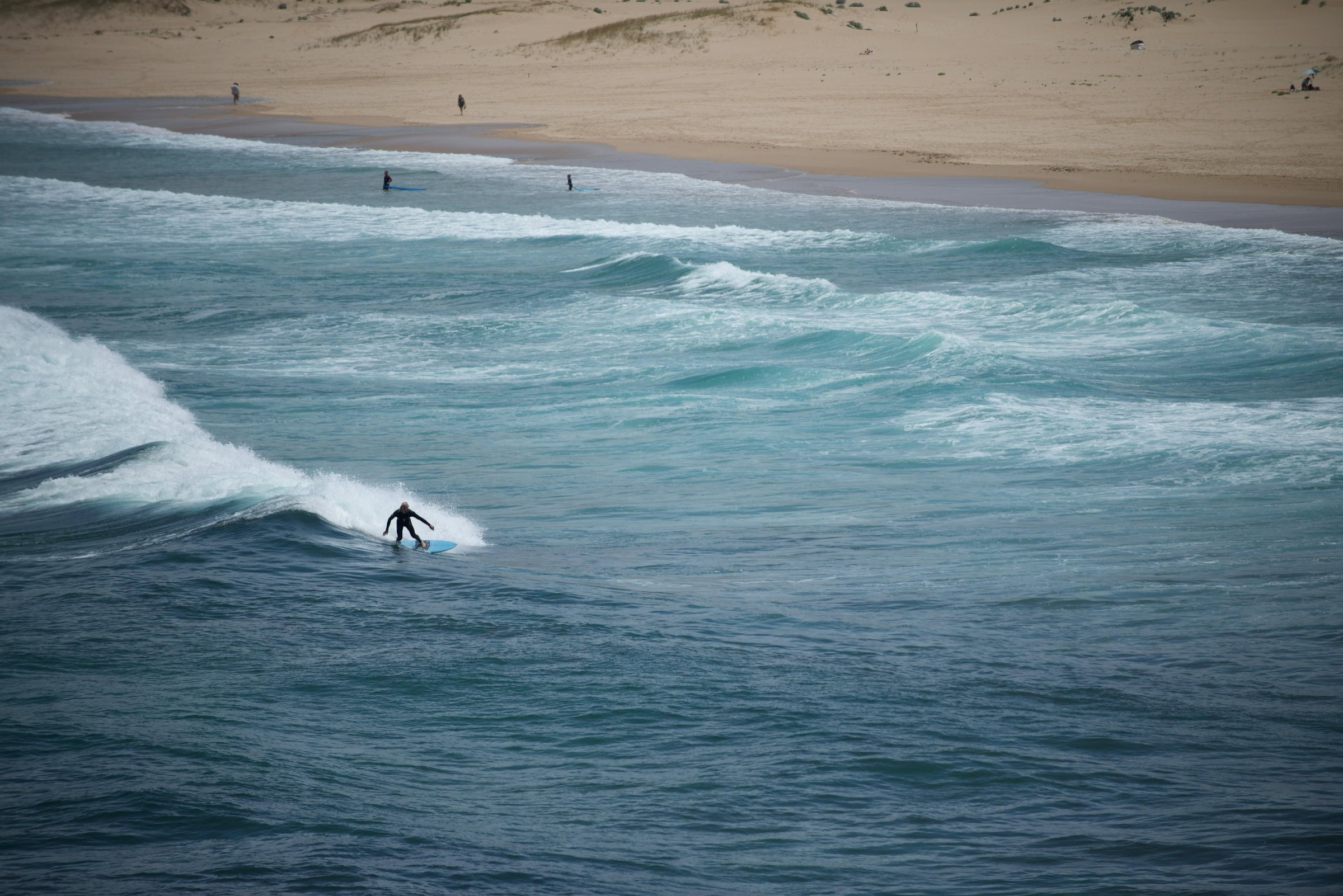 Aerial view of Meia Praia beach with surfers and scenic Algarve coastline
