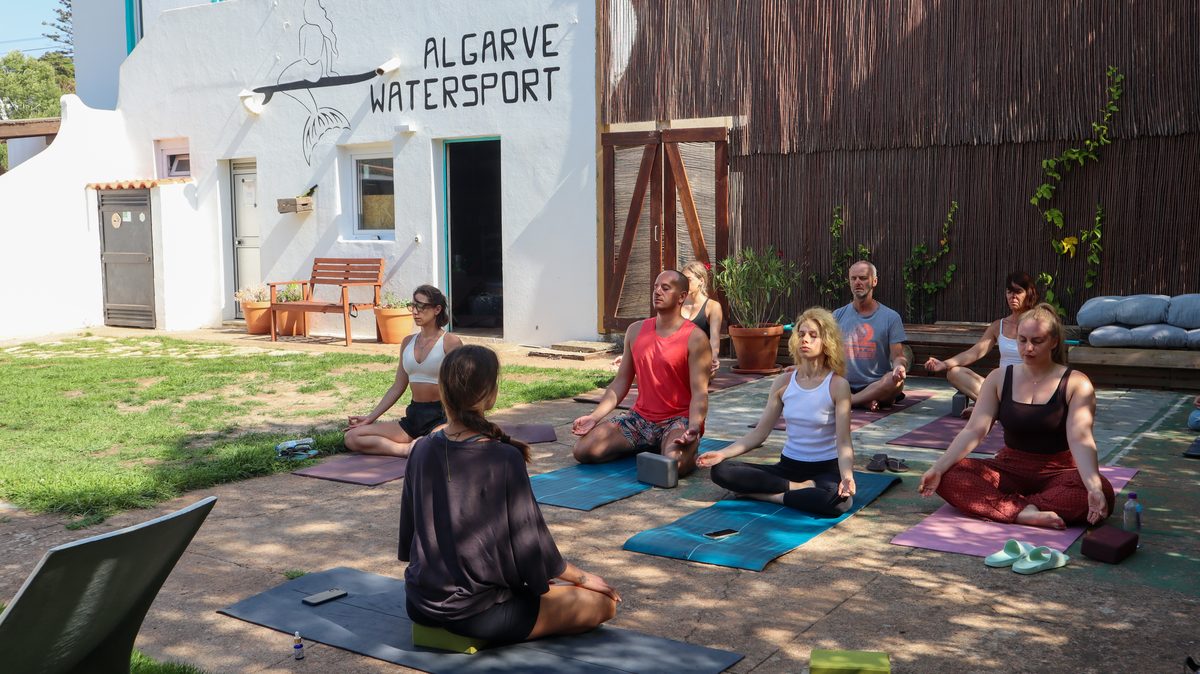 Group yoga and meditation session in the garden at Algarve Watersport surf camp Lagos