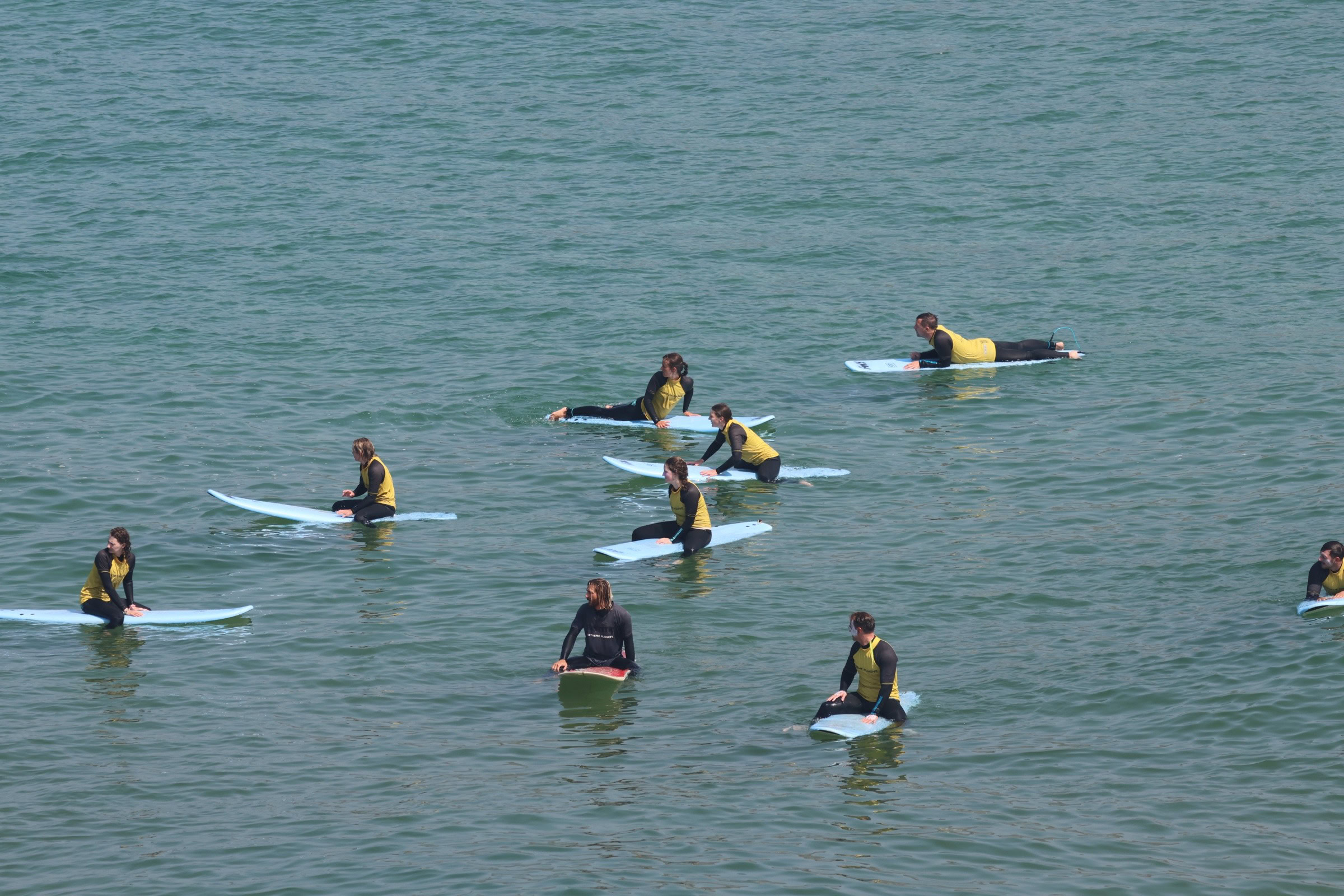 Surf group sitting on their boards in the lineup, waiting for waves — Algarve