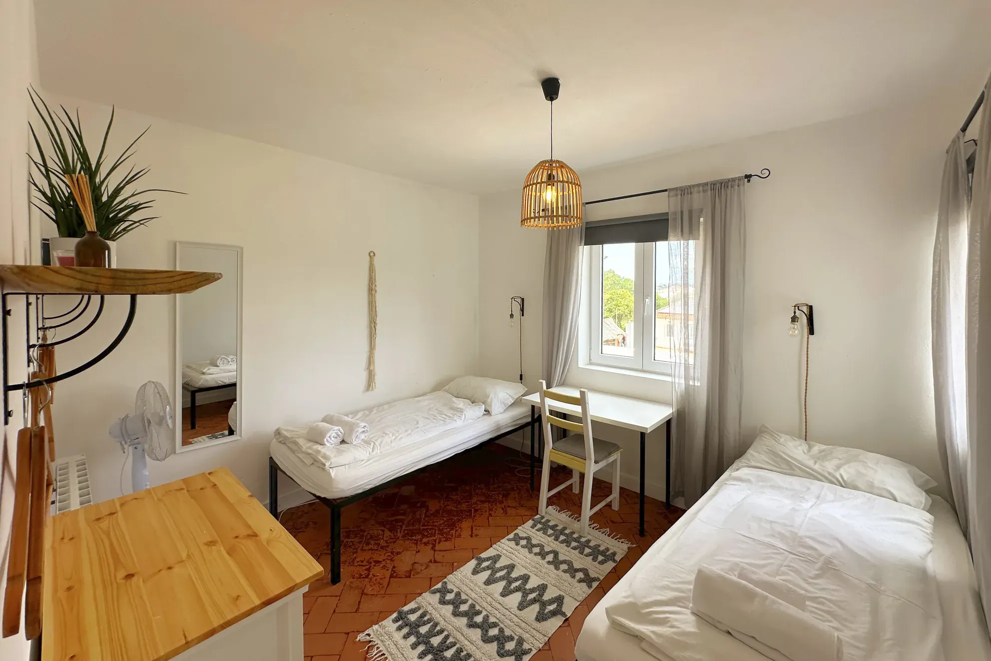 Twin room Amado with two single beds, desk and rattan pendant lamp at Algarve Watersport surf camp