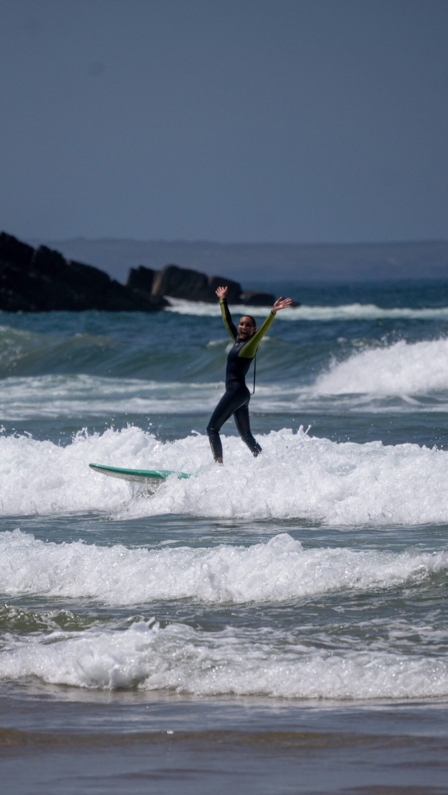 Solo surfer celebrating after catching a wave at Algarve surf camp