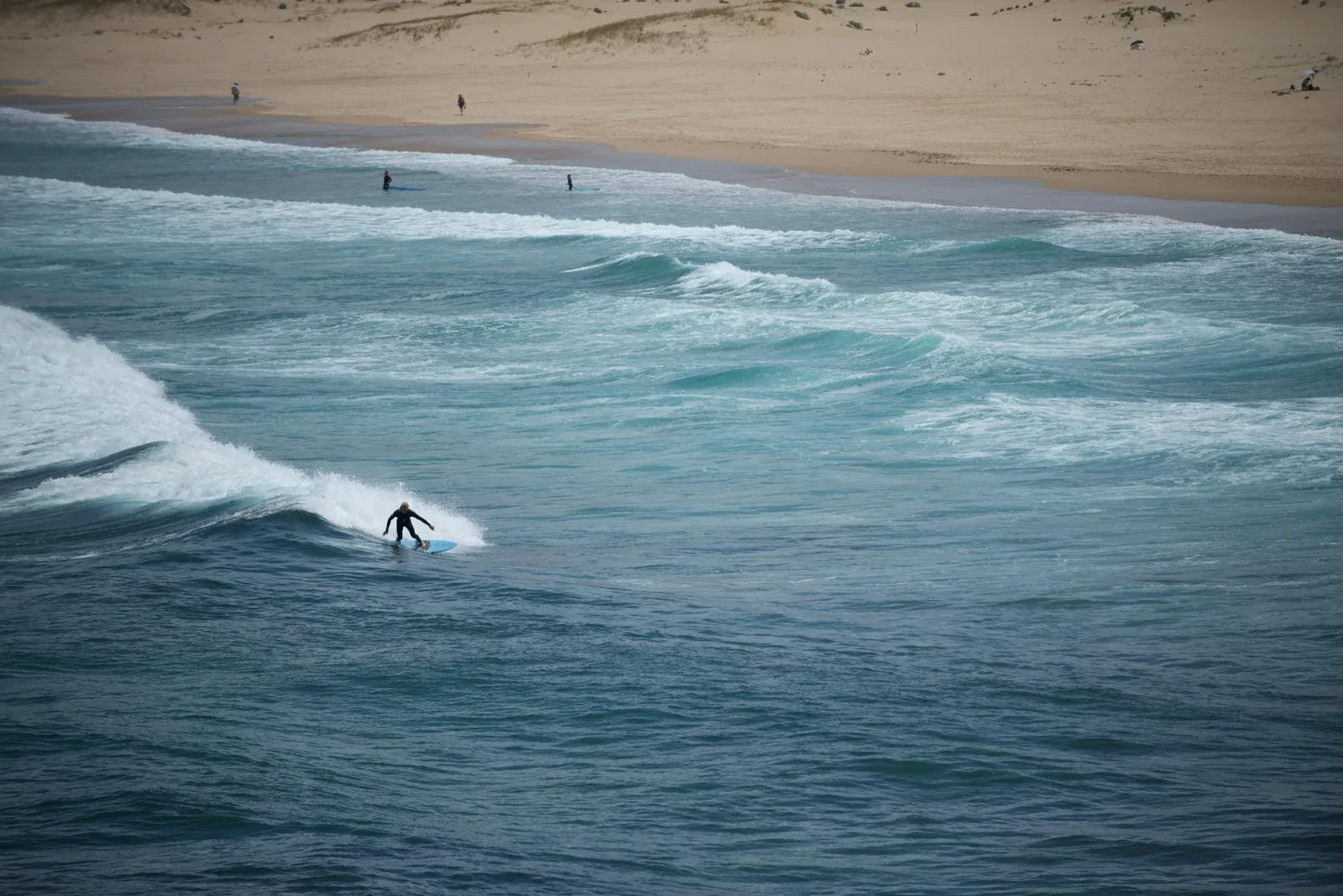 Vista aerea di Meia Praia con surfisti e la panoramica costa dell'Algarve