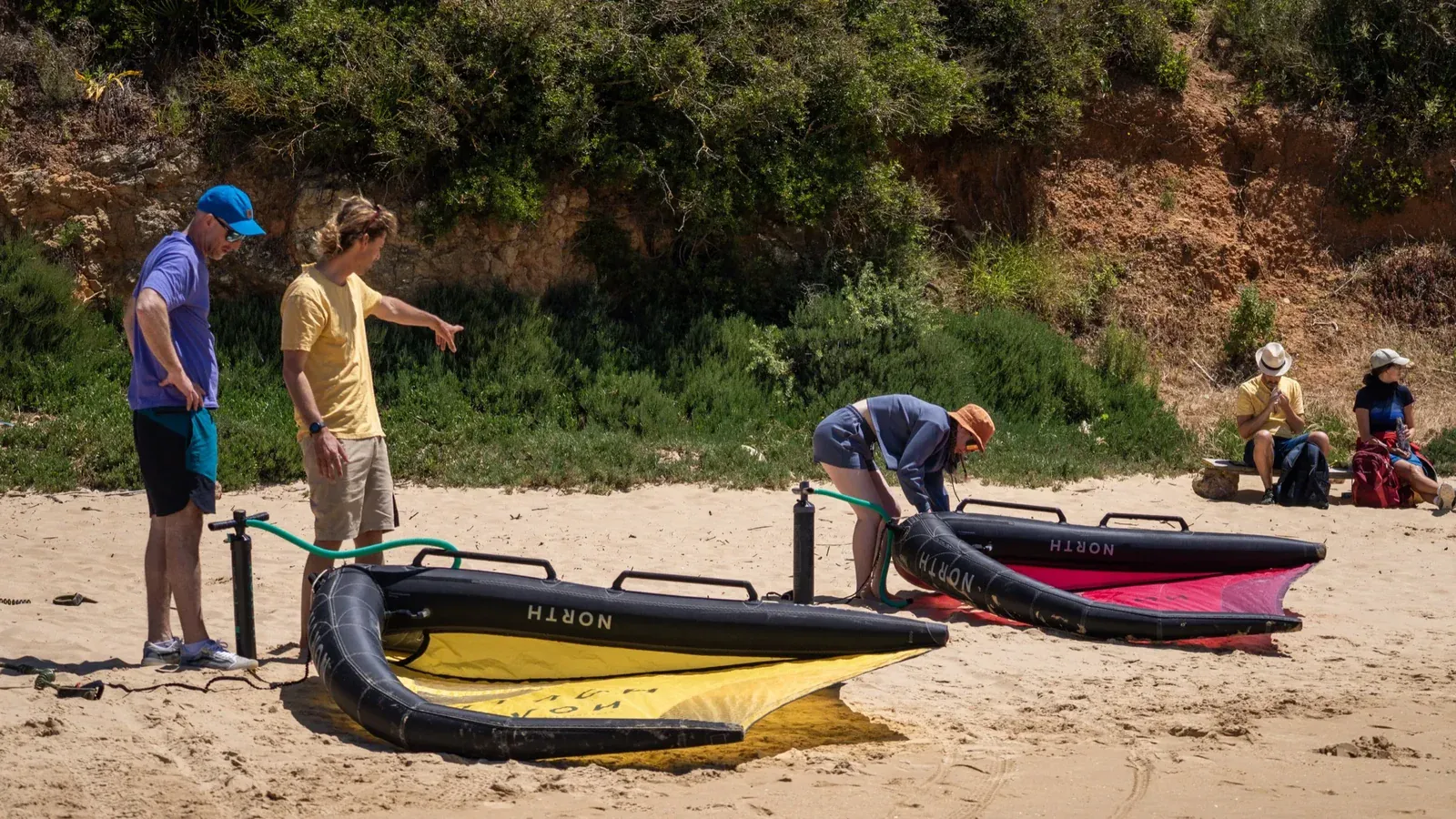 Wing foil instruktor vysvětluje nastavení wingu studentům na pláži v Algarve Watersport Lagos