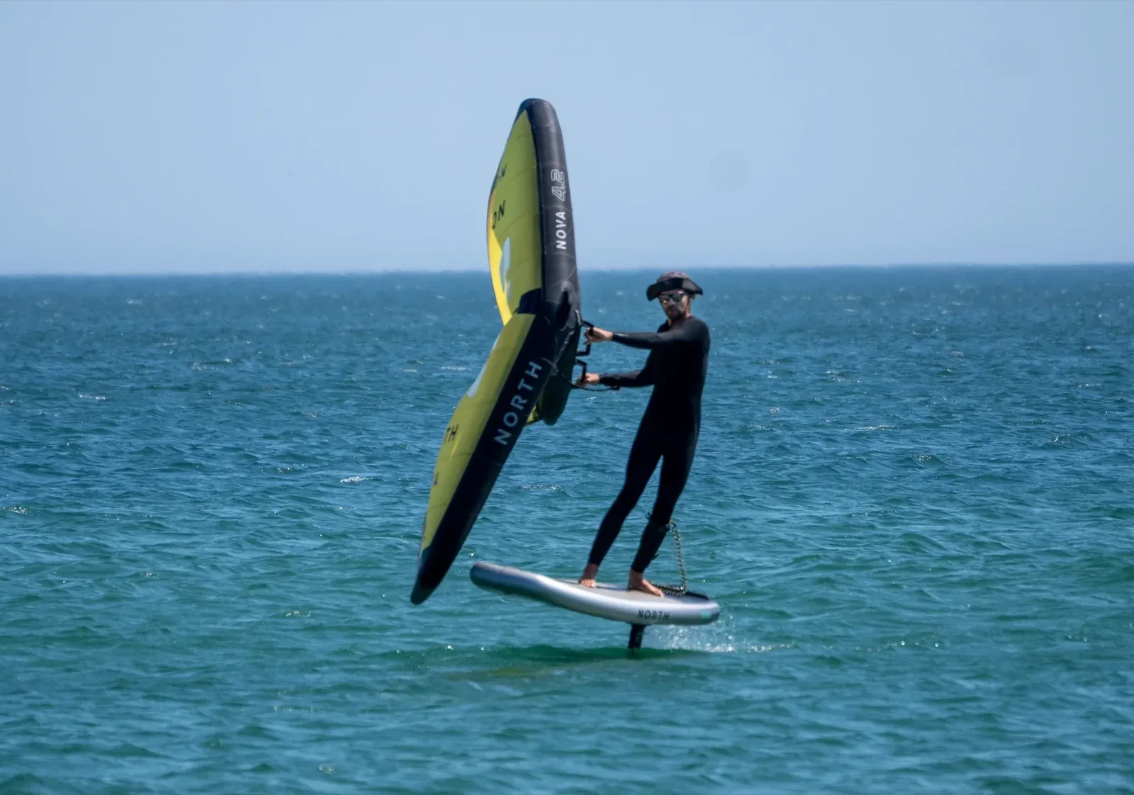 Wing foil rider foiling at Meia Praia beach Lagos Algarve
