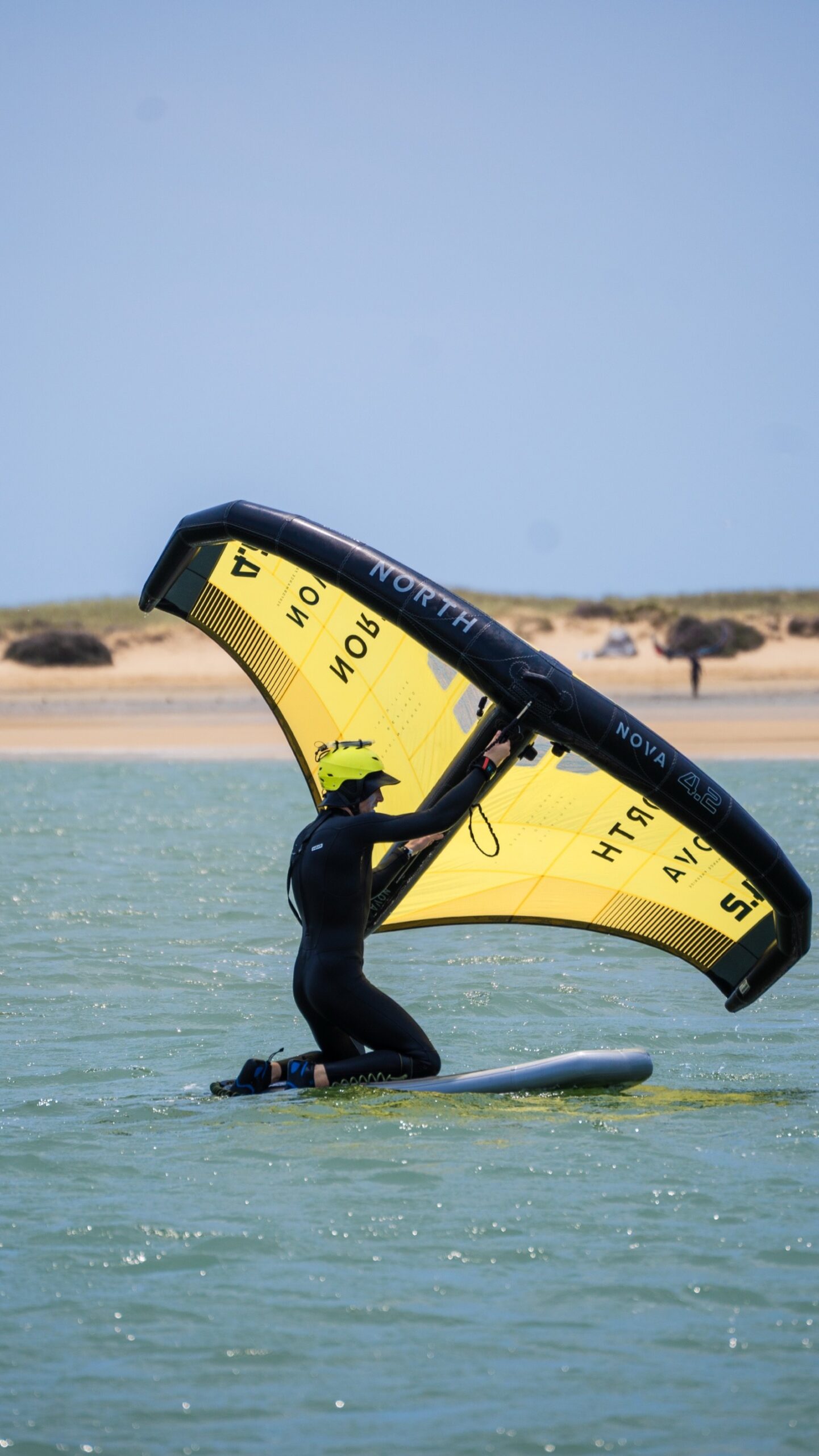 Beginner wingfoil student on board at Alvor lagoon