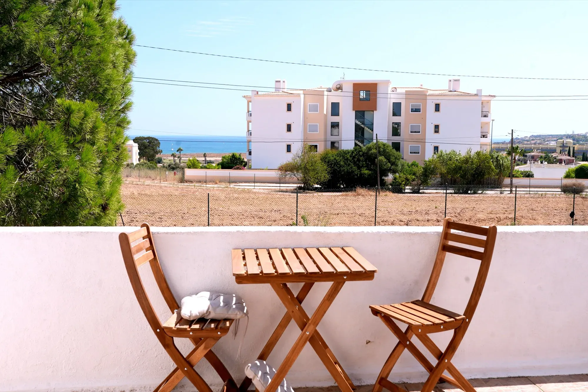 Upstairs terrace with table, chairs and a distant sea view at Casa Alegria Lagos
