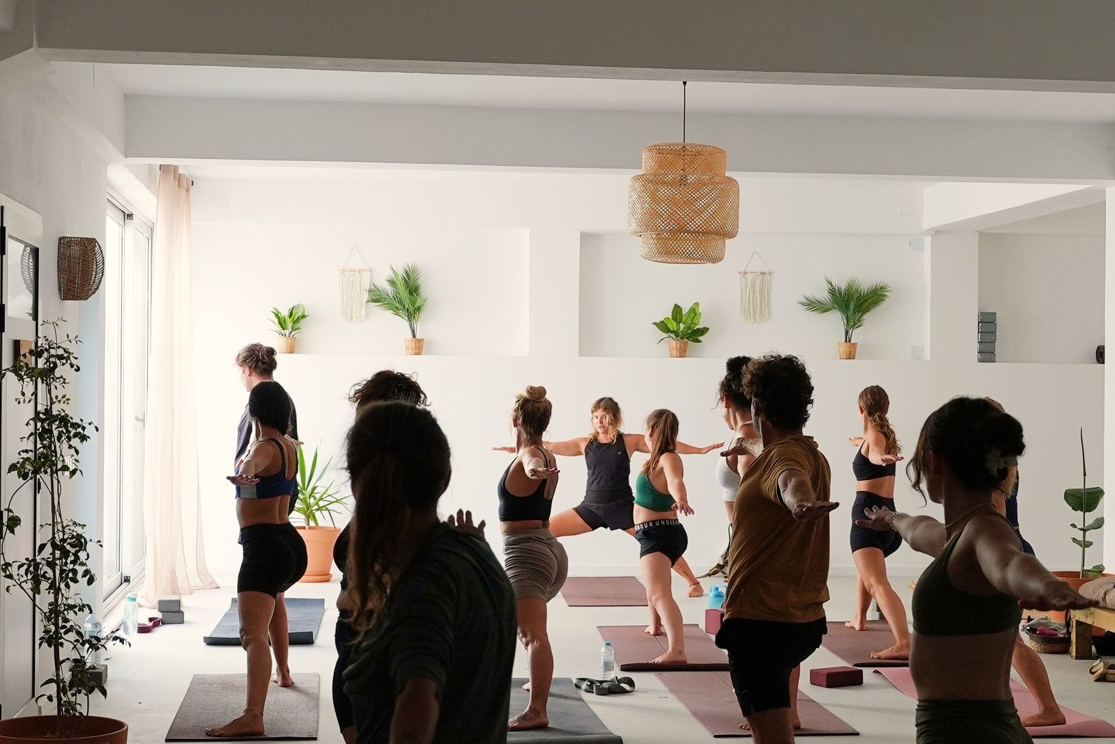 Group doing Warrior II pose during a yoga class at The Hill, Algarve Watersport, Lagos